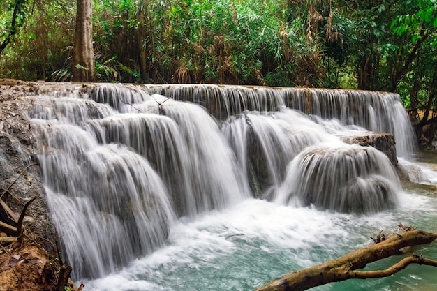 The waterfall and small cool pond with turquoise water. Concept of ecological tourism. Fantastically beautiful nature with clear water forest and wild jungle. Kuang Si Waterfalls in Luang Probang Laos