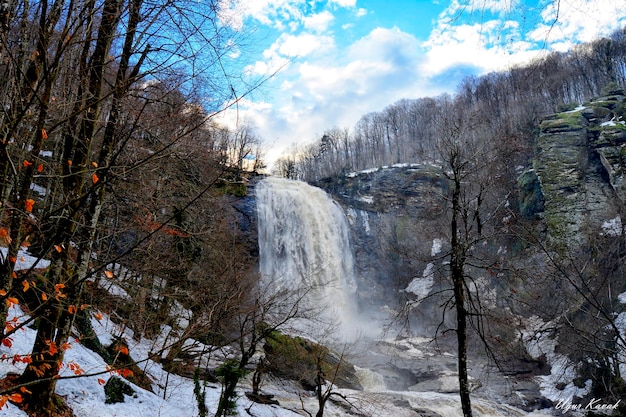 Foto una cascata nella neve con sopra la scritta 