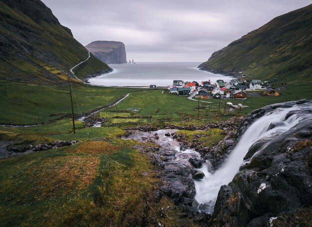 Waterfall and the village of Tjornuvik in the Faroe Islands