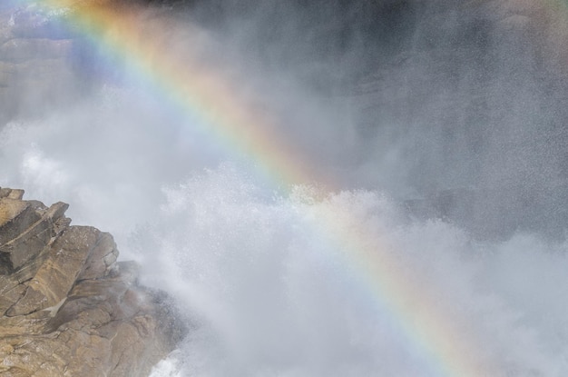 Cascata con nebbia e arcobaleno