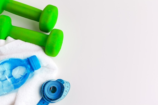 Waterfles en fitnessapparatuur op witte achtergrond wordt geïsoleerd die