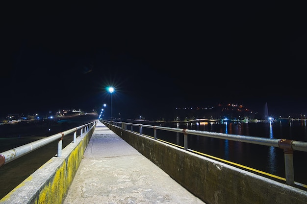 Waterfront path next to lake illuminated at night