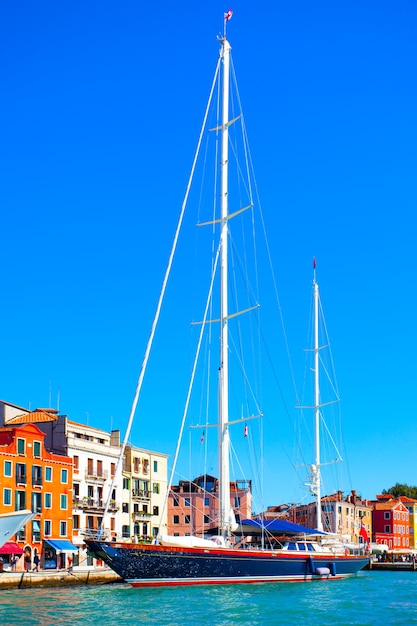 Набережная Венеции и пришвартованная парусная яхта с высокими мачтами, Италия