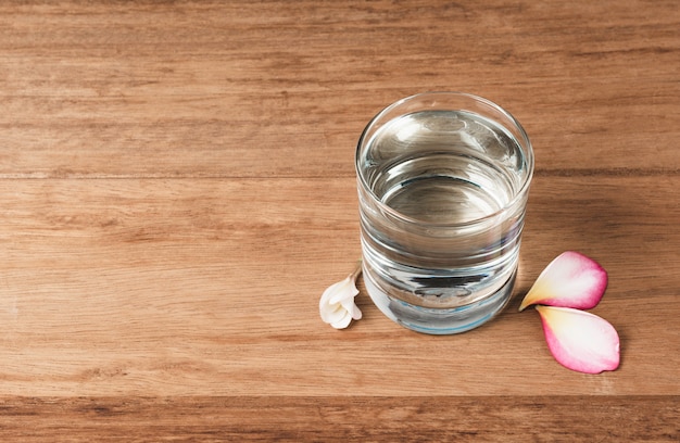 Waterglas op houten lijst. Glas en schoon drinkwater met kopie ruimte.