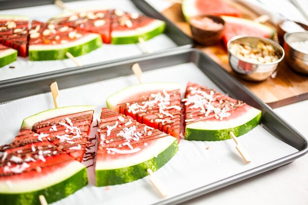 Watermeloen besprenkeld met chocolade en gegarneerd met vlokken zeezout en kokos.