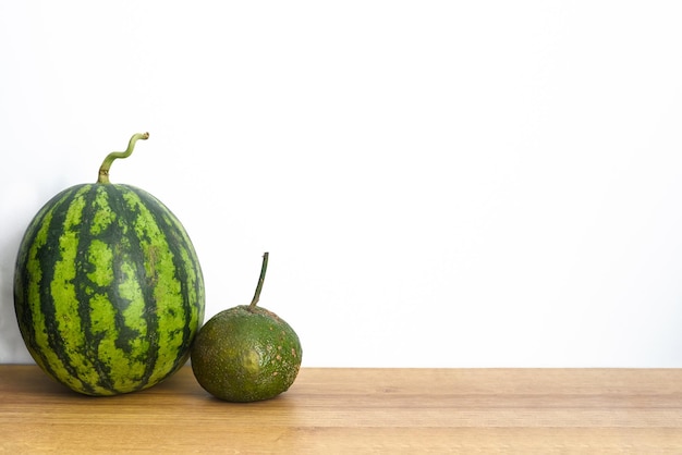 Watermeloen en citrusvruchten op een houten tafel tegen een witte achtergrond