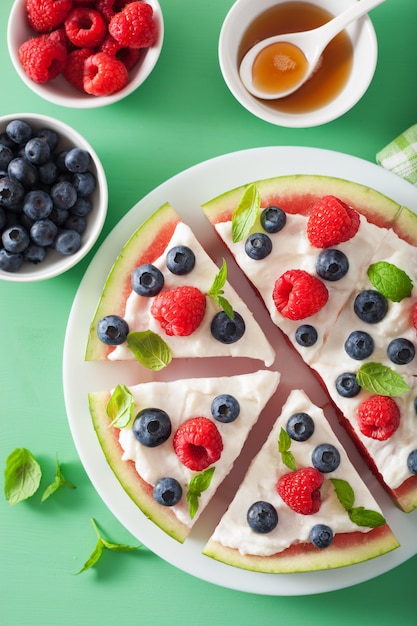 Watermeloen pizza segmenten met yoghurt en bessen, zomer dessert