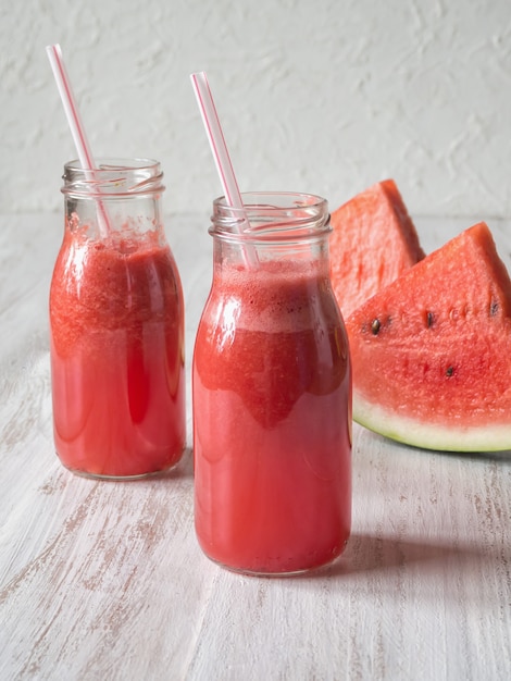 Watermeloen smoothie op een witte houten tafel.