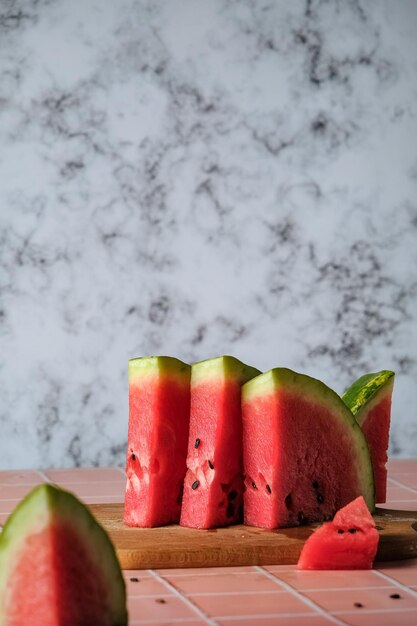 watermeloenplakken op een tegeltafel, watermeloen op een lichtmarmeren achtergrond, vers en gekoeld waterm