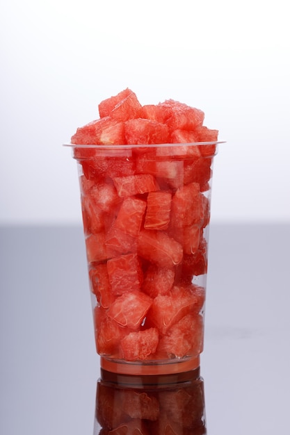 Watermeloenschijfjes, gerangschikt in een transparant glas op een witte achtergrond, geïsoleerd