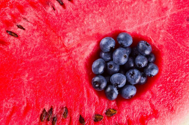 Watermelon and blueberries on white background The process of eating watermelon with spoon