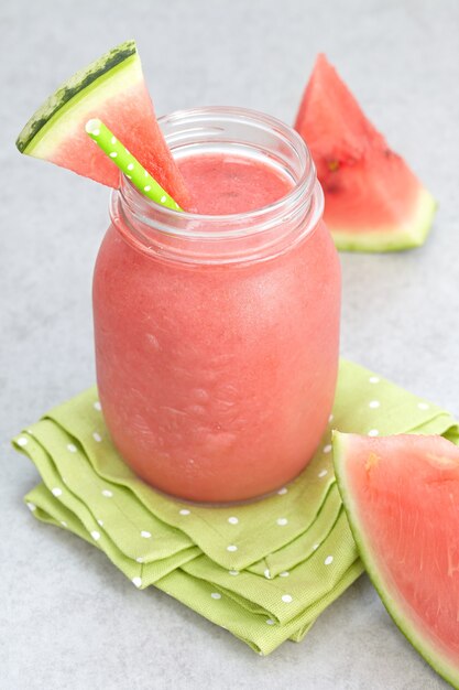 Watermelon drink in a glass jar with slices of watermelon