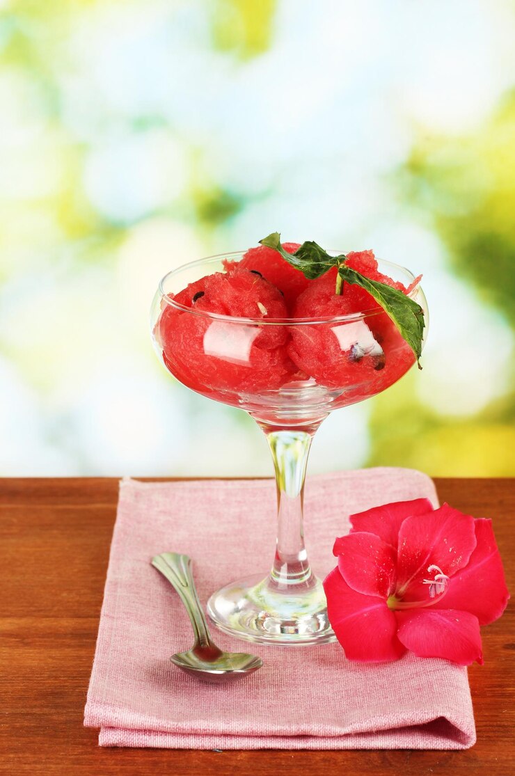 Photo watermelon ice cream in a glass goblet on green background closeup
