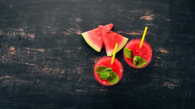 Watermelon juice with mint and ice in a glass Melon On a black wooden background Free space for text Top view