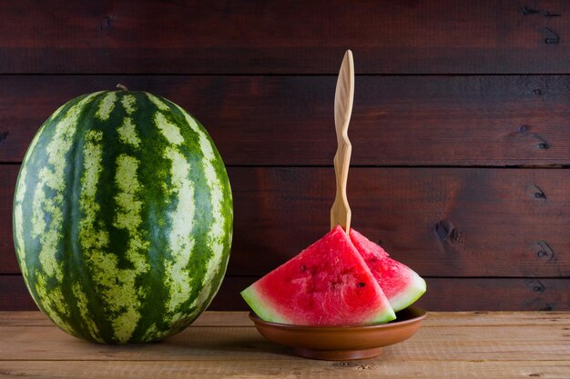 Watermelon op houten planken Hele watermeloen op houten achtergrond Gezond voedsel voor veganisten Kopieerruimte