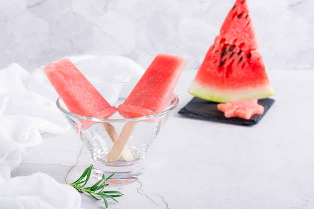 Watermelon popsicles in a bowl and a piece of watermelon on the table Homemade dessert