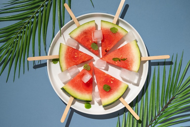 Watermelon popsicles in a plate with ice cubes Summer food background