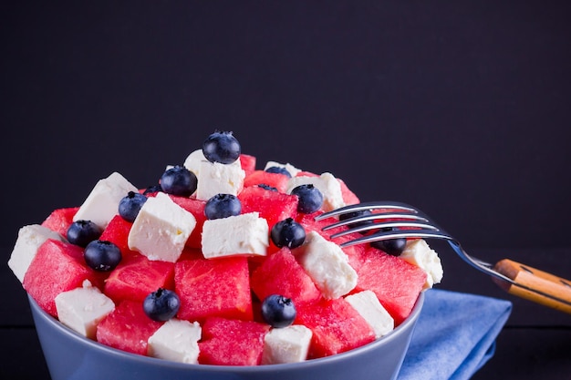 Watermelon salad with feta cheese in gray bowl Healthy salad with blueberries watermelon