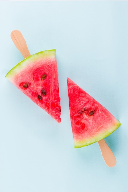 Watermelon slice popsicles op een turquoise achtergrond Verse watermelon op houten stokken