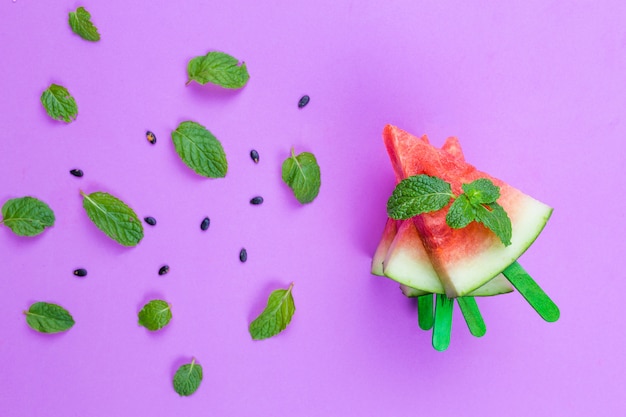 watermelon slice popsicles on a pink  background