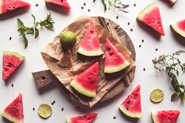 Watermelon on a sliced board with mint and slices of lime. food