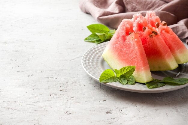 Watermelon sliced on a plate with mint leaves 