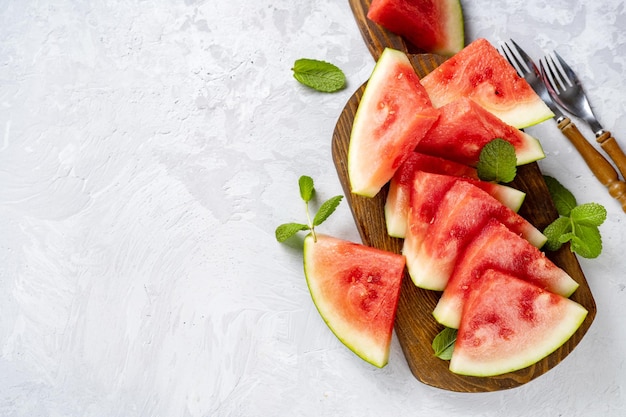 Watermelon slices on wooden board and light background close up summer food vitaminized raw