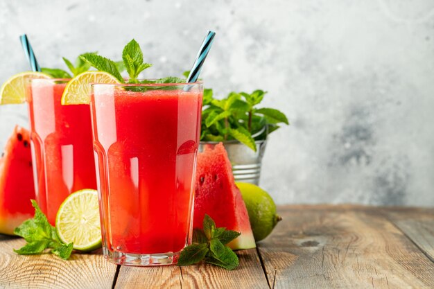 Watermelon slushie with lime and mint summer refreshing drink in tall glasses on a light background sweet cold smoothie with copy space