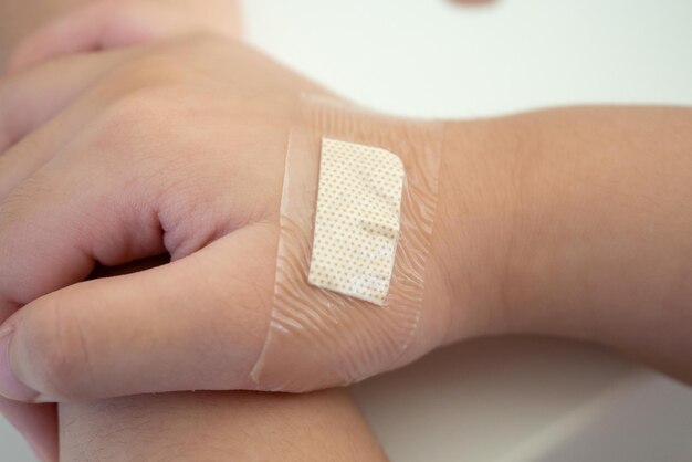 Photo waterproof adhesive plaster on little kid hand