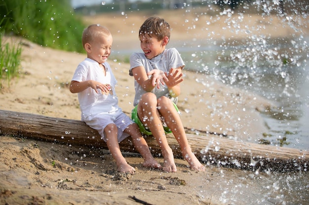 Waterspatten vliegen naar spelende kinderen op de rivieroever