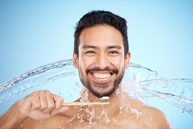 Waterspattend portret of man die tanden poetst in de studio met tandenborstel voor witte tanden of mondverzorging Gezichtstandpasta of gelukkig persoon die de mond schoonmaakt of wast met een gezonde tandglimlach