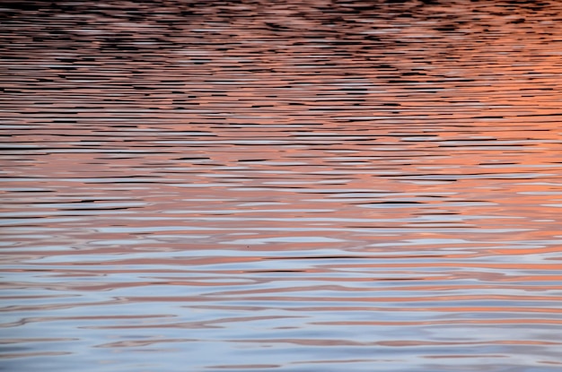 Watertextuurpatroon bij zonsondergang aan de Atlantische Oceaan