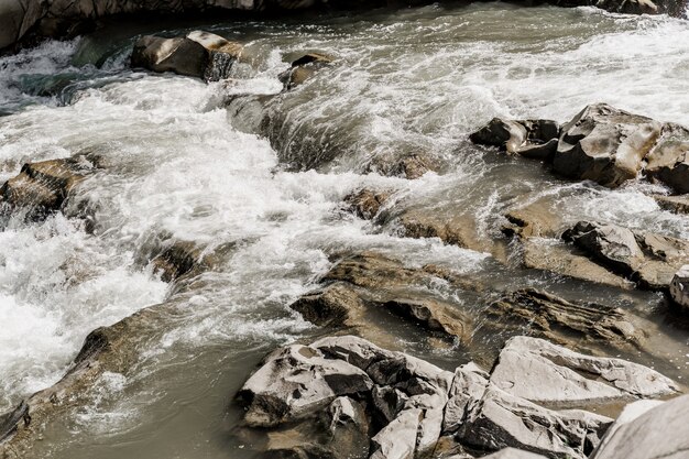 Waterval in de bergrivier met grote rotsen