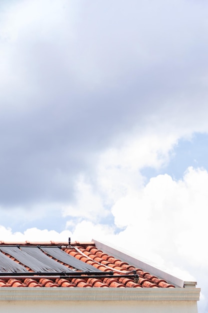 Waterverwarmingssysteem op het dak van het huis op een zonnige en bewolkte dag