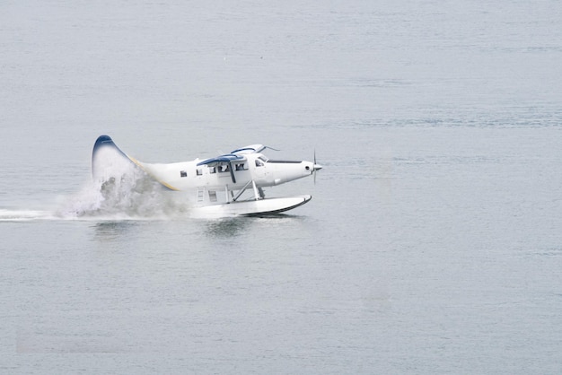 Watervliegtuig landing in de lagune van de oceaan Het opstijgen van een watervliegtuig vanaf het oceaanstrand met spatten op het wateroppervlak