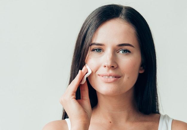 Wattenschijfje vrouw gezicht verwijderen make-up gezonde huid natuurlijke make-up. studio opname.