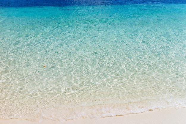 Photo wave of blue ocean on sandy beach. background.