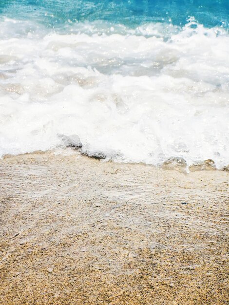 Wave of blue ocean on sandy beach Summer Background