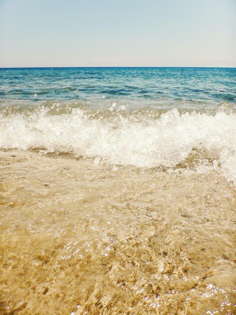 Foto onda dell'oceano blu sulla spiaggia sabbiosa summer background