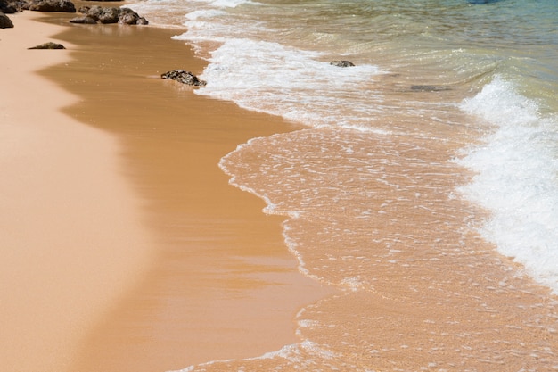 Wave of blue sea on sandy beach. Background.