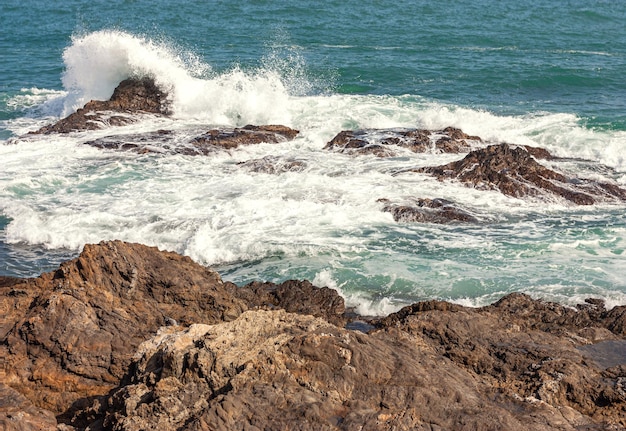 A wave breaking against a rock in the sea