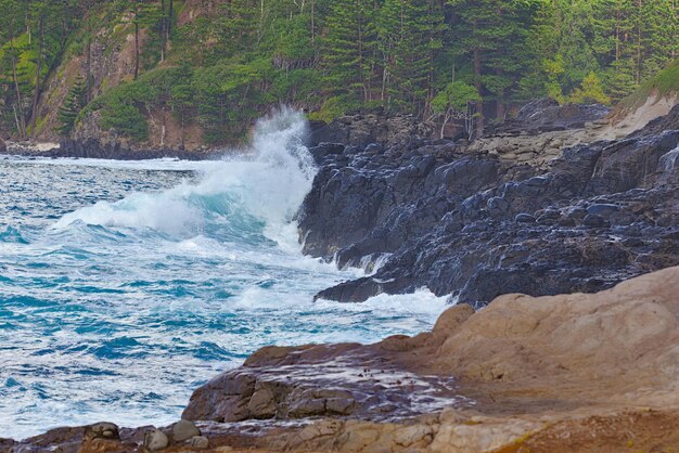 Photo wave breaking against the rocky shore