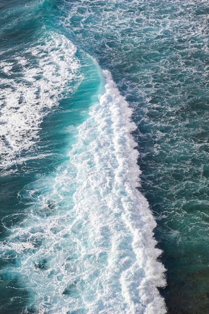 A wave breaks on the ocean with the word ocean on the bottom