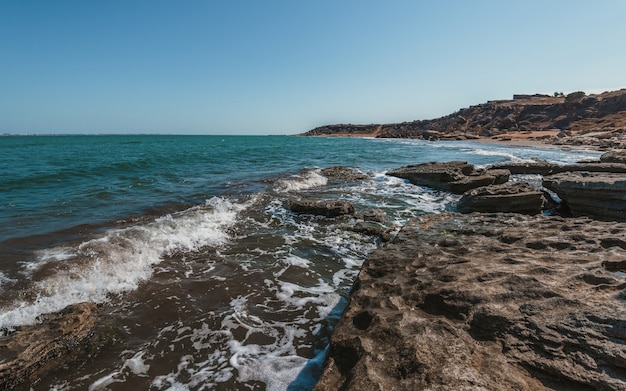 The wave breaks on the rock