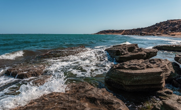 The wave breaks on the rock