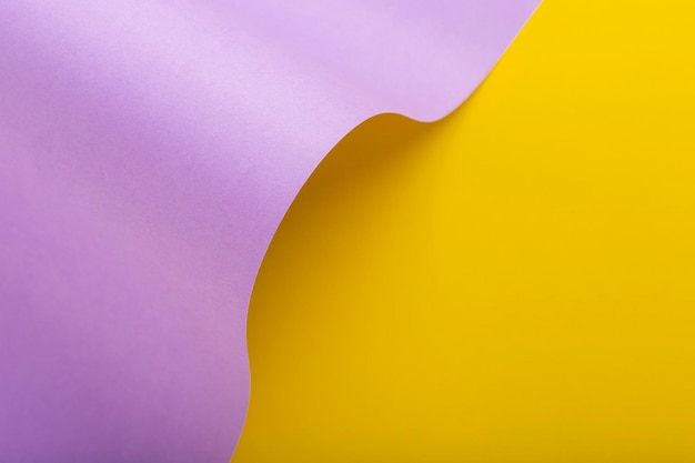 Wave from lilac cardboard on a yellow background. Top view, flat lay.