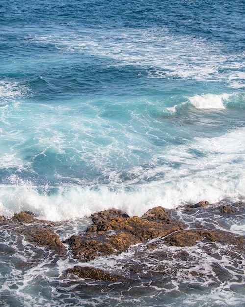 波が打ち寄せる波から海の海のしぶきでビーチの海の水しぶきで岩にぶつかる波