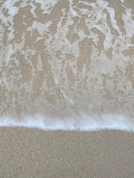 A wave is crashing on the beach and the water is white