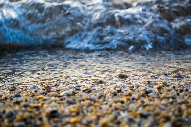 Wave near the shore a coastline of fine sand together with pebbles