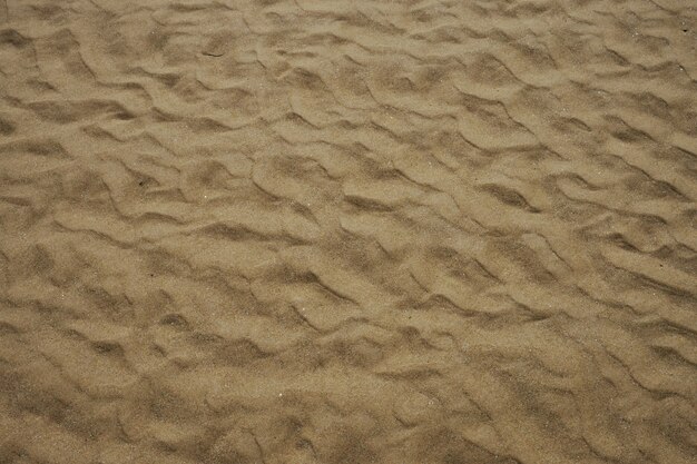 プーケット島の繊細な砂の質感を示す影のある朝の波砂ビーチ